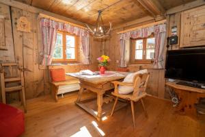 ein Esszimmer mit einem Tisch in einer Hütte in der Unterkunft Berghaus am Sonnenhang Valpaschun in Valchava