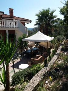 un patio con una mesa y una sombrilla blanca en La casa di Antonella en Vico del Gargano