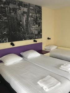 2 Betten in einem Zimmer mit einem Bild an der Wand in der Unterkunft Hotel De Weyman in Santpoort-Noord