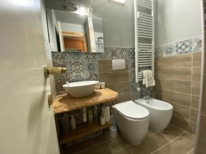 La salle de bains est pourvue d'un lavabo, de toilettes et d'un miroir. dans l'établissement Appartamento Ducale Val Di Luce, à Abetone
