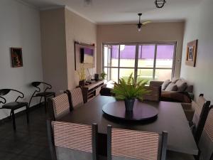 a living room with a table and chairs and a couch at Apt. Enseada Guarujá in Guarujá