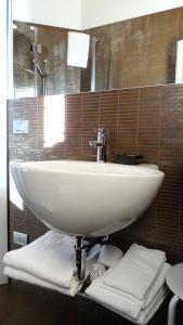 a white sink in a bathroom with brown tiles at Magrine Castelfranco Veneto in Castelfranco Veneto