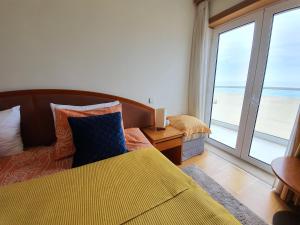 a bedroom with a bed and a view of the ocean at Nazare apartamento em frente ao mar in Nazaré