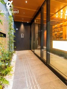a walkway in front of a building with glass doors at ALPHABED INN Fukuoka Ohori Park / Vacation STAY 65802 in Fukuoka