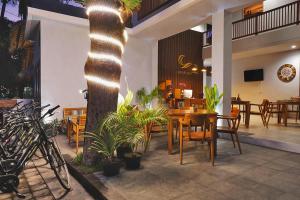 a restaurant with a table and chairs and a tree at Gili Kama Hotel & Villa in Gili Trawangan