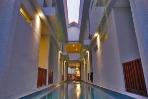 a hallway with a swimming pool in a building at Gili Kama Hotel & Villa in Gili Trawangan