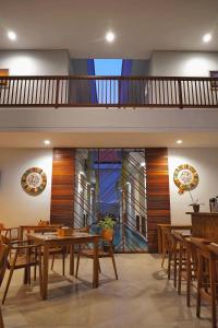 吉利特拉旺安的住宿－Gili Kama Hotel & Villa，一间带桌子和木椅的用餐室
