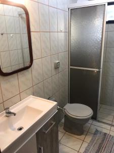 a bathroom with a toilet and a sink and a mirror at Casa na praia 02 in Itapema