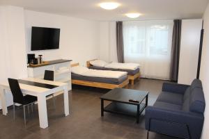 uma sala de estar com um sofá e uma mesa em Libarty Appartments em Kornwestheim