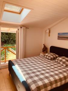 a bedroom with a checkered bed in front of a window at La Cabane du Bois in Arcachon