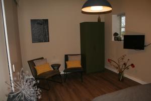 a living room with two chairs and a television at B&B Agnetenhoeve in Overasselt