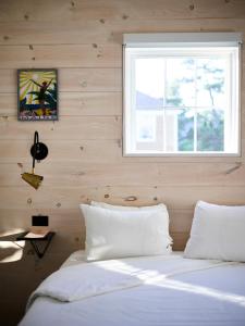1 cama con almohadas blancas en una habitación con ventana en Higgins Beach Inn, en Scarborough