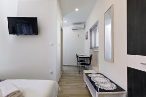 1 dormitorio con 1 cama y TV en la pared en Apartments Stella Spalato, en Split