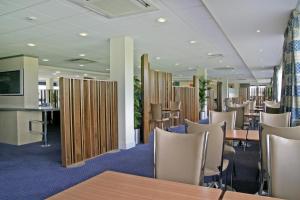 a room with a table and chairs in it at Holiday Inn Express Cardiff Airport, an IHG Hotel in Rhoose