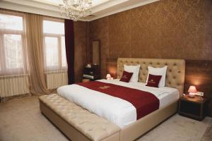 Un dormitorio grande con una cama grande con sábanas rojas y blancas. en Hotel King David The Builder, en Kutaisi