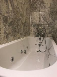 a white bath tub in a bathroom with a tile wall at Eurobar & Hotel in Oxford