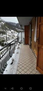 un balcón con nieve en el suelo de un edificio en da Nicola e Greta, en Miroglio