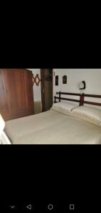 a bedroom with a large bed with white sheets at da Nicola e Greta in Miroglio