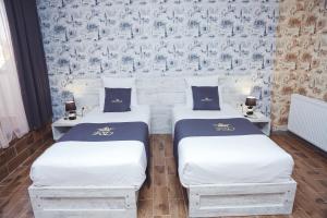 two twin beds in a room with a wall at Hotel King David The Builder in Kutaisi