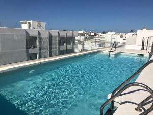 a swimming pool on the roof of a building at Apartamentos Cachón in Zahara de los Atunes