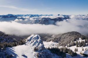 een berg bedekt met sneeuw met wolken op de achtergrond bij Obere Maxlraineralm in Spitzingsee