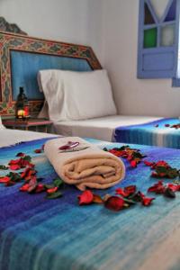 a towel on a bed with flowers on it at Hotel Ouarzazate in Chefchaouen