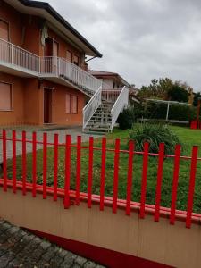 een rood hek voor een huis bij Alloggio Cristina in Valdobbiadene