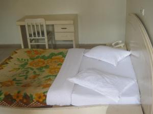 En eller flere senger på et rom på Hotel Le Fibi