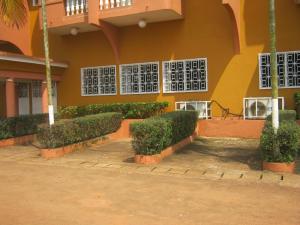 a building with bushes in front of a building at Hotel Le Fibi in Yaoundé