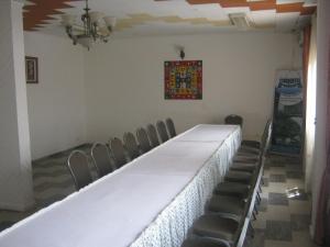 Hotel Le Fibi في ياوندي: غرفة فيها طاولة وكراسي طويلة