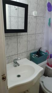 a bathroom with a sink and a toilet and a mirror at Departamentos Berna in Valdivia +25 photos