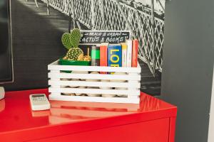 a red dresser with a stack of books and a phone at Beach & Urban Attic in Alicante