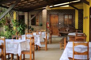 a restaurant with tables and chairs and a couch at Pousada Aruanã in Arraial d'Ajuda