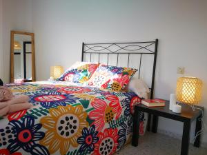 a bedroom with a bed with a colorful comforter at Apartamento playa de Levante in La Línea de la Concepción
