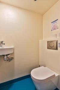 a bathroom with a white toilet and a sink at Hotelschip Bracksand Amsterdam City, in de zomer én de winter! in Amsterdam