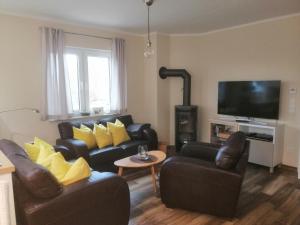 a living room with two couches and a flat screen tv at Haus Ostwind in Zinnowitz