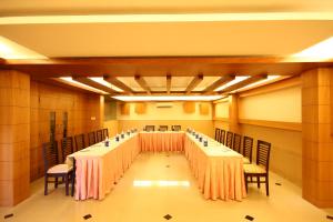 Habitación grande con mesas y sillas. en Hotel Crescent Crest Sriperumbudur, en Sriperumbudur
