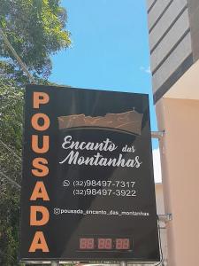 una señal para un restaurante al lado de un edificio en Pousada Encanto das Montanhas, en Caparaó Velho