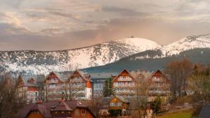 a town with snow covered mountains in the background at Apartament z widokiem. in Karpacz
