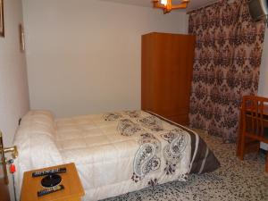 a bedroom with a bed and a dresser at Hostal San Pedro in Sanlúcar la Mayor