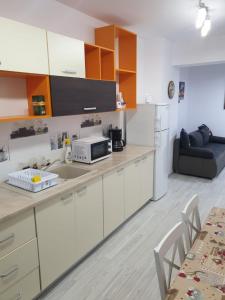 een keuken met een aanrecht met een magnetron en een bank bij Topaz Central Apartment in Bacău