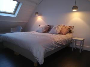 a bedroom with a bed with white sheets and pillows at TY KERLUZ - Vue Mer et Plage à 80m in Locquirec