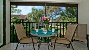 a table with a vase of flowers on a balcony at Shorewalk Vacation Villa in Bradenton