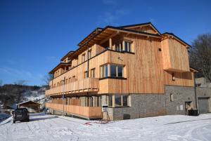 a large wooden building in the snow at Apartment Iva in Cerny Dul