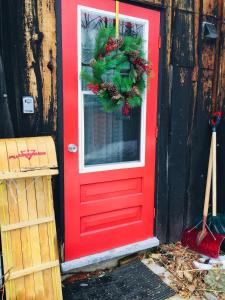 czerwone drzwi z wienkiem świątecznym w obiekcie Le Rustique Orford Domaine Cheribourg w mieście Magog-Orford