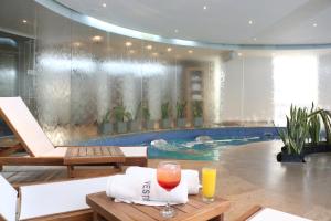 uma piscina com uma mesa com dois copos de sumo de laranja em Club Campestre De Bucaramanga em Bucaramanga