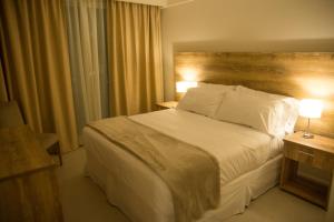 a bedroom with a large white bed and a window at NAVARRO PLAZA HOTEL in Navarro