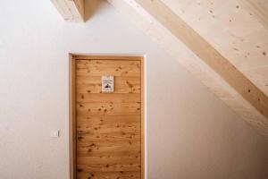 - une porte dans une chambre dotée d'un mur en bois dans l'établissement Apartment Špica - Private parking, à Kranjska Gora