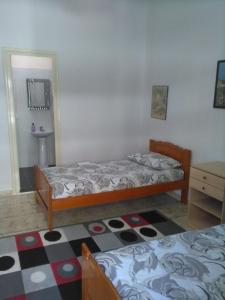 a bedroom with two beds and a sink in it at Vila Sula Guesthouse in Durrës