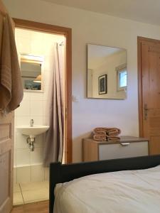 a bathroom with a bed and a sink and a mirror at Central Morzine, Spacious 2 Bedroom Family Apartment in Morzine